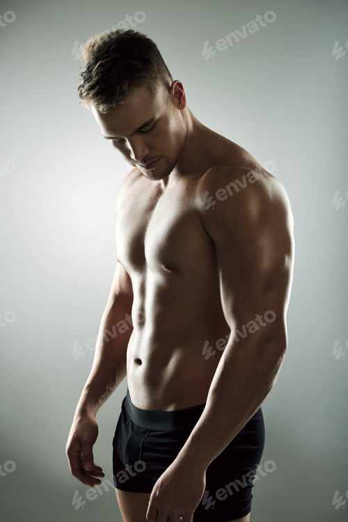 Preview: Hes a muscle making machine. Studio shot of a muscular young man posing against a grey background.