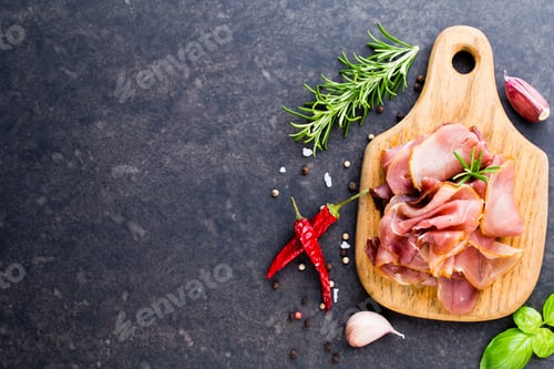 Preview: Prosciutto with rosemary on a black background.