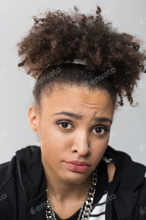 Preview: portrait of upset african american girl with curly hair isolated on grey