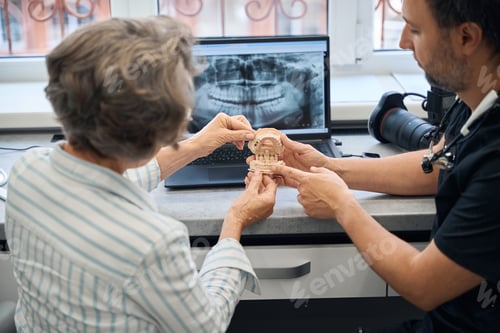 Preview: Male dental technician is consulting an elderly lady