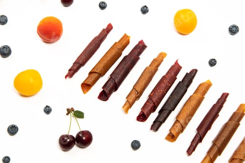 Preview: Pattern pastila fruit leather rolls up with fruits on white background. Horizontally.