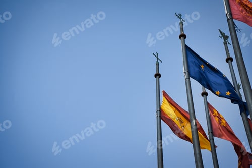 Preview: Various flags waving against a bright blue sky,