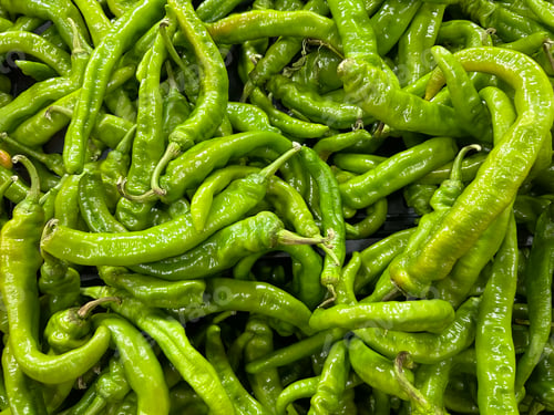 Preview: A close-up of a large pile of fresh green chili peppers