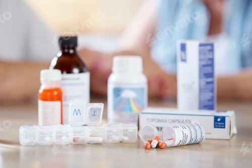 Preview: Cropped shot of medication on a kitchen table with an unrecognizable couple in the background