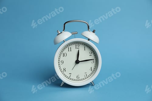 Preview: One white alarm clock on light blue background