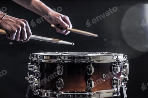 Preview: Man plays musical percussion instrument with sticks.