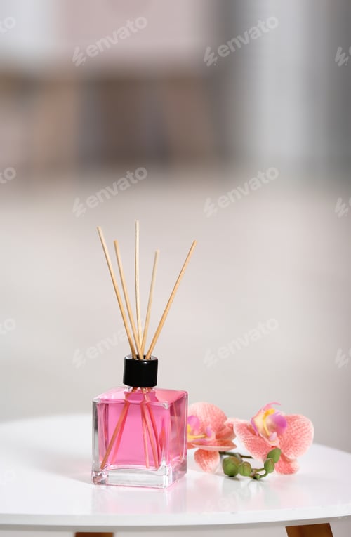 Preview: Aromatic reed air freshener and flowers on table against blurred background