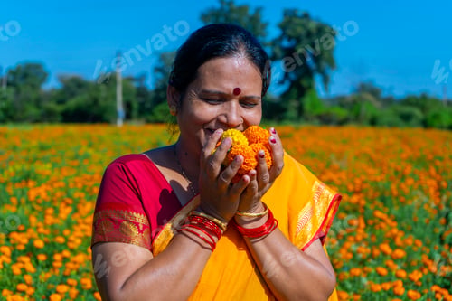 Preview: Indian woman in marigold field and enjoying nature.