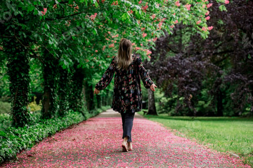 Preview: woman walking down barefoot at alley with blossom trees
