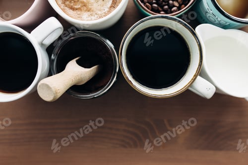 Preview: Multiple coffee cups, milk, beans and ground coffee in jar on wooden background