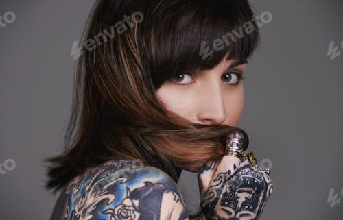 Preview: A cropped studio portrait of a beautiful tattooed young woman