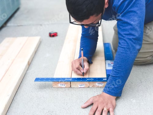 Preview: Man taking measurements on wood for a diy project