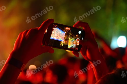 Preview: Closeup of female hands taking a video with smartphone on blur background