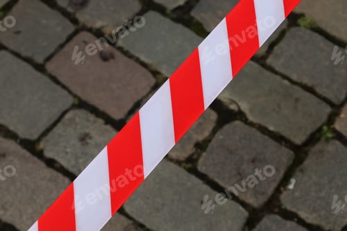 Preview: Closeup shot of red and white warning tape with brick walls background