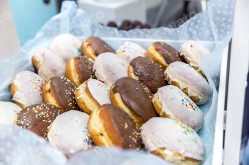 Preview: Closeup of donuts ion a tray under the lights with a blurry background