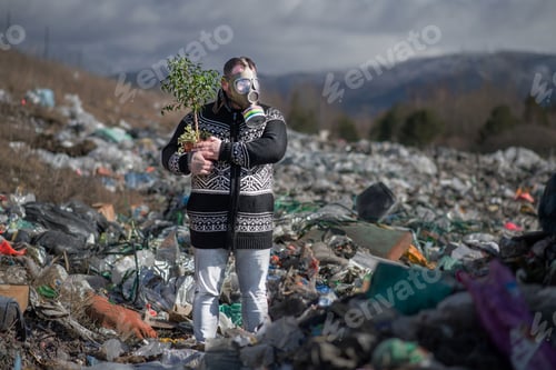 Preview: Man with gas mask and plant on landfill, environmental concept