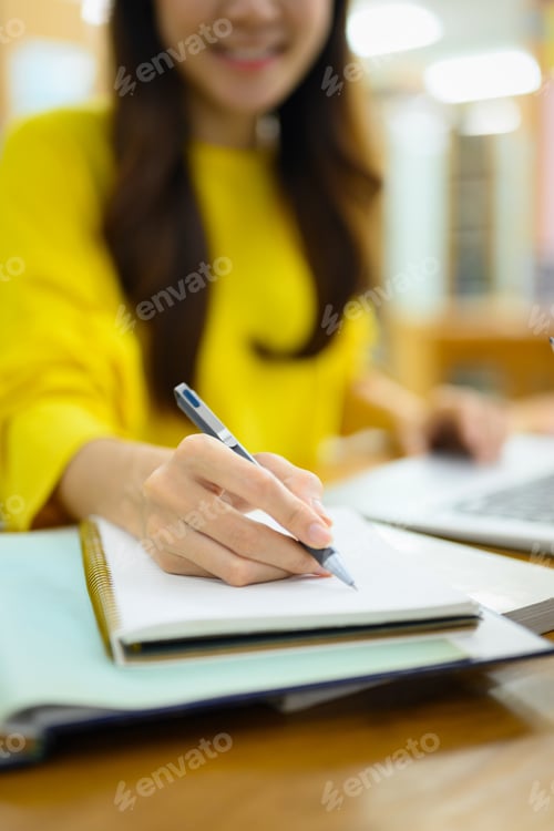Preview: Select focus on hand. Young female student doing class assignment, preparing for exam.