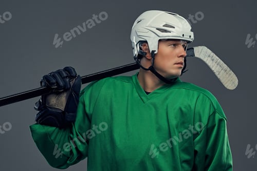 Preview: Hockey player wearing black protective uniform holds a hockey stick on a gray background.