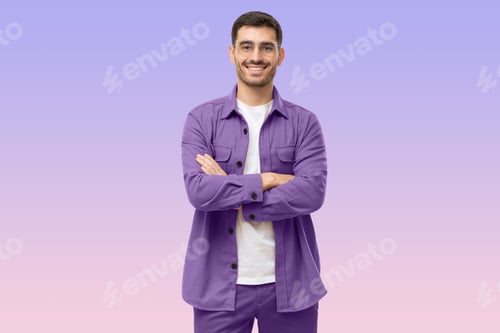 Preview: Young male teacher standing with crossed arms, wearing casual purple shirt, looking at camera