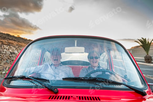Preview: nice adult couple hug and love inside a red old vintage car parked on the road
