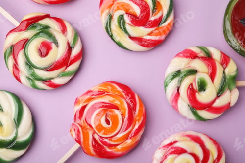 Preview: Many colorful lollipops on violet background, flat lay