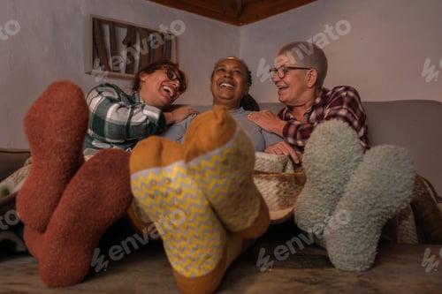 Preview: Photo of female friends sitting with winter socks and enjoying a chocolate in the cold winter.