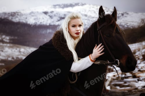 Preview: Woman viking with a black horse against the background of mountains