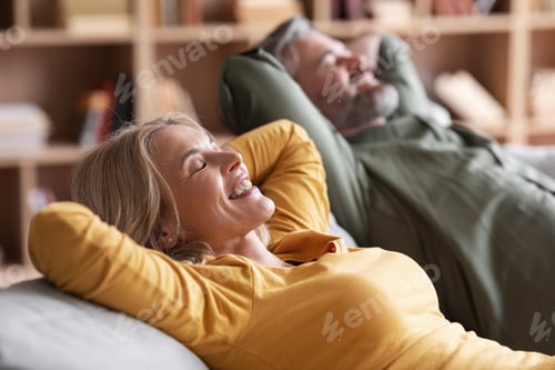 Preview: Happy Relaxed Middle Aged Spouses Leaning Back On Comfortable Couch