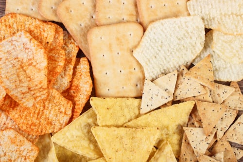 Preview: Heap of crunchy cookies and salted potato crisps, concept of unhealthy food