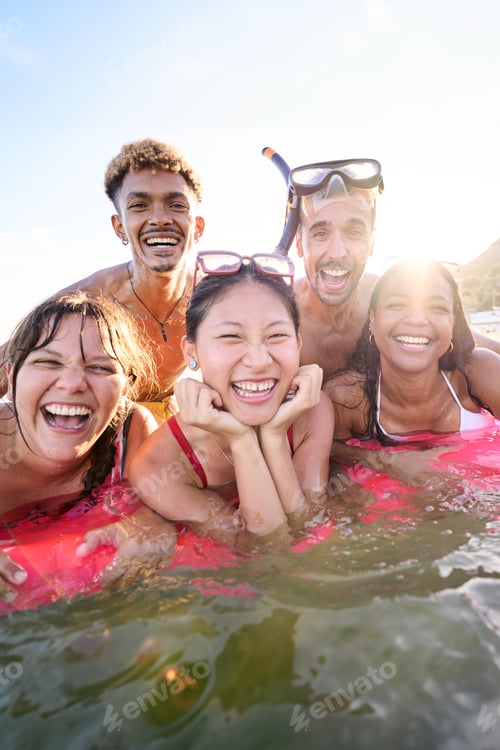Preview: Portrait of group of multiracial people laughing looking at the camera in bikini