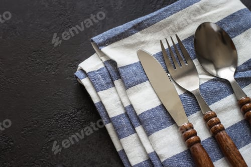 Preview: Food cooking background. Careless simple table setting. Set of cutlery with wooden handles.