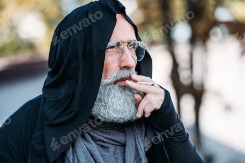 Preview: portrait of stylish senior man smoking cigarette on street