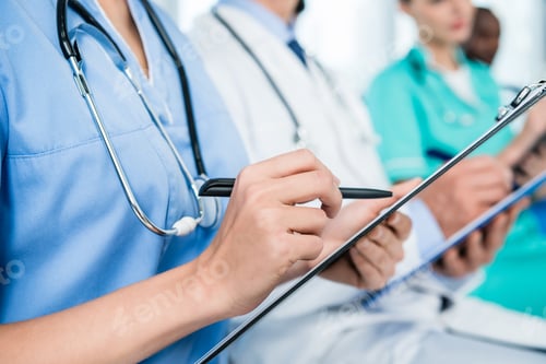 Preview: cropped shot of nurse writing in clipboard on conversation