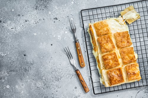 Preview: Turkish cheese stuffed filo dough borek or Su boregi. Gray background. Top view. Copy space