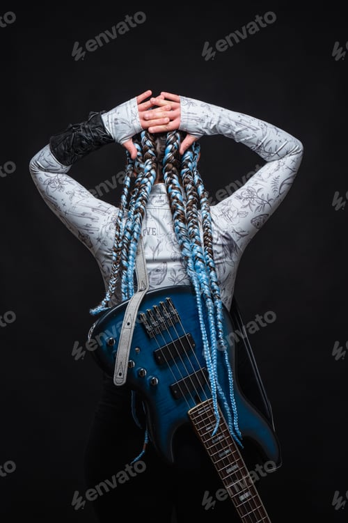 Preview: Female bass player with blue boxer braids, posing for a photoshoot on a black background. Authentic.
