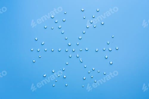 Preview: Snowflake from water drops on a blue background. Concept of thaw and snow melt