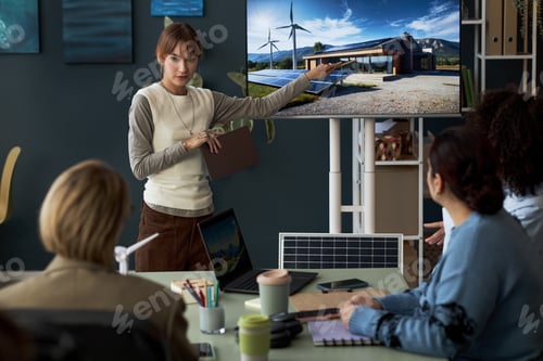 Preview: Woman Presenting New Building To Colleagues At Meeting