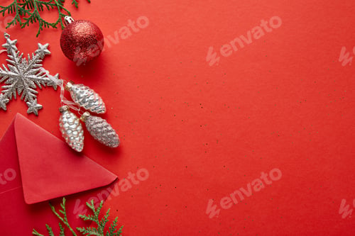 Preview: top view of shiny Christmas decoration, envelope and thuja on red background with copy space