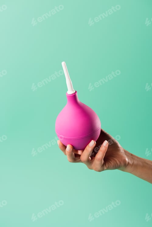 Preview: cropped shot of person holding enema isolated on green