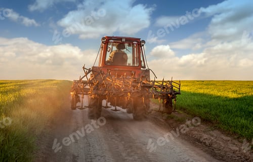 Preview: tractor on the road at sunset. Silhouette of old tractor in country road on the way to home.