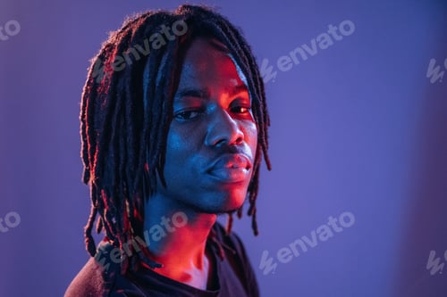 Preview: Professional portrait. African American guy is studio with neon lighting