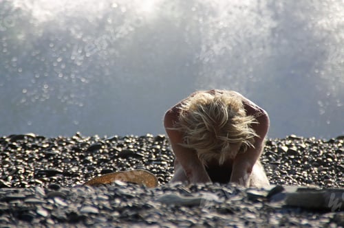 Preview: Blond female sitting on the stony beach of Granada