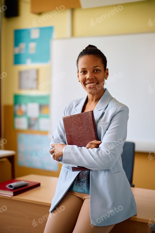 Preview: Portrait of happy black elementary school teacher looking at camera.