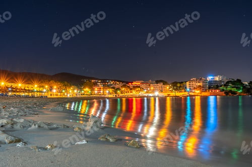 Preview: Tranquil night scene of the sea illuminated by the soft lights of the shoreline in Mallorca, Spain