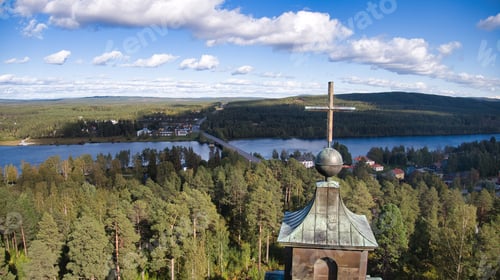 Preview: Aerial view of a clock tower in a picturesque wooded area, surrounded by lush foliage