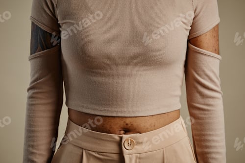 Preview: Close up of unrecognizable woman wearing crop shirt in neutral color