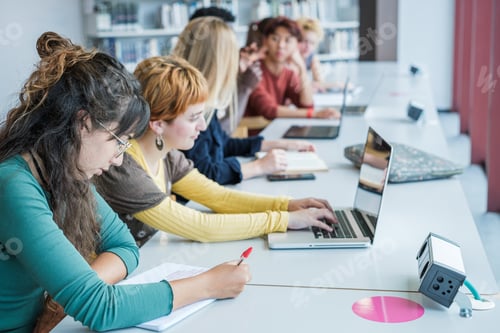 Preview: Group of college students studying together in the library
