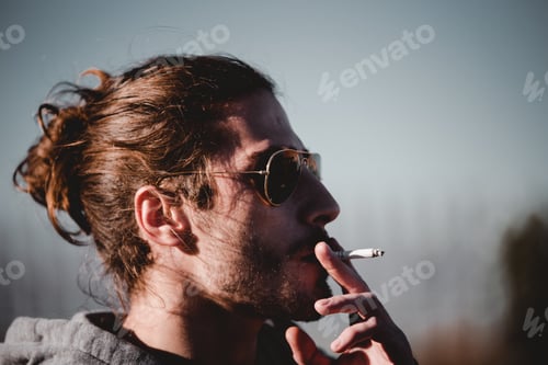 Preview: Handsome man smoking in nature