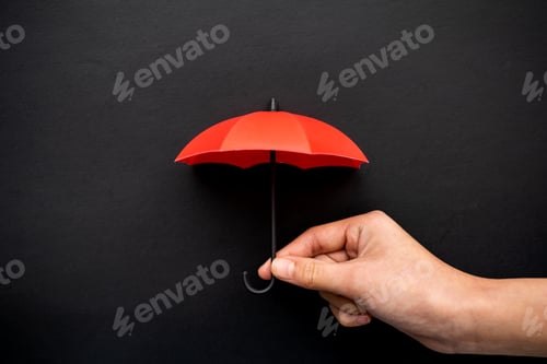 Preview: Hand Holding a Small Red Umbrella on Black