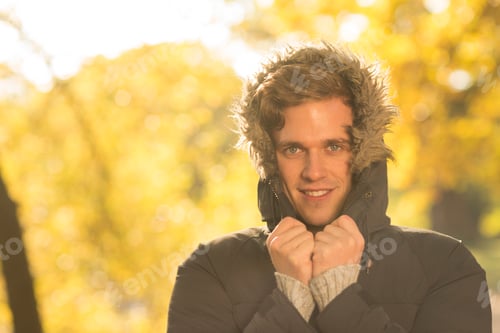 Preview: Portrait of young man with hood up, in rural setting